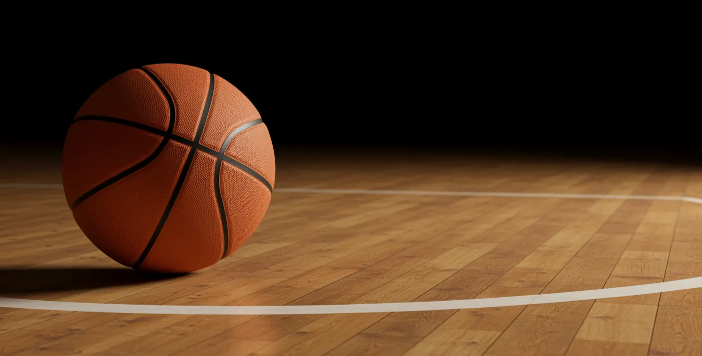 Ballon de basket-ball orange rebondissant sur un parquet de salle de sport, éclairage de gymnase en arrière-plan